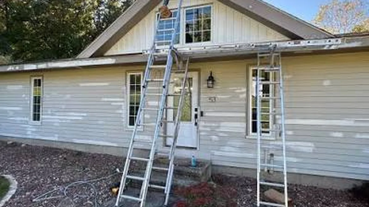 Painter working on Seattle home exterior during summer dry season