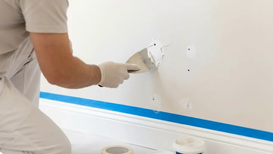 Professional painter preparing walls in Everett home — filling holes and applying primer before painting