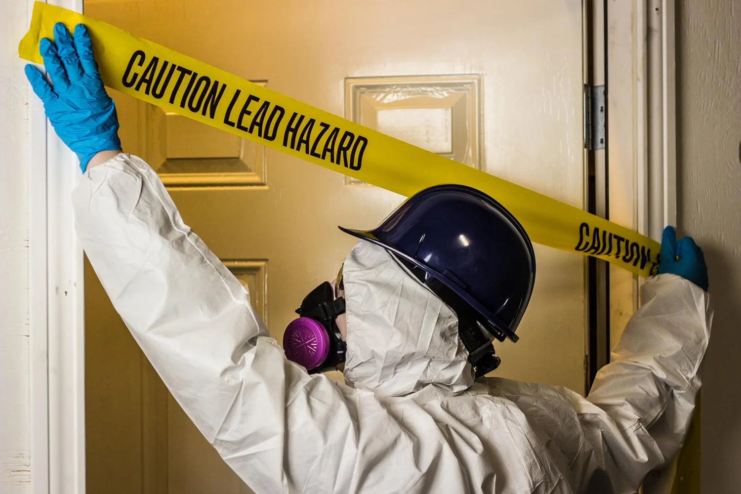 EPA RRP certified painter in protective gear working on older Seattle home